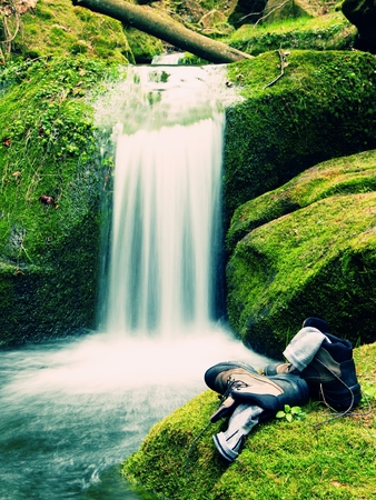 Hiker high boots and sweaty grey socks. Resting on the boulder at the  nice mountain streamの写真素材
