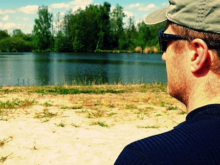 Man is sitting on the beach at lakeの写真素材
