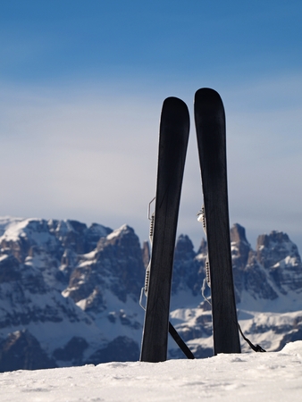 Small fun skis in snow at mountains, nice sunny winter day at peakの写真素材