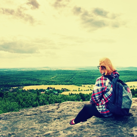 Young Woman hiker takes a rest on peak of the Mountainの写真素材