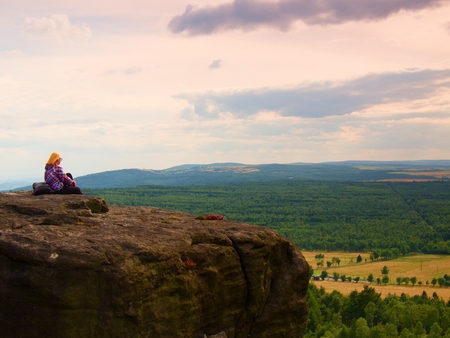 Young Woman hiker takes a rest on peak of the Mountainの写真素材