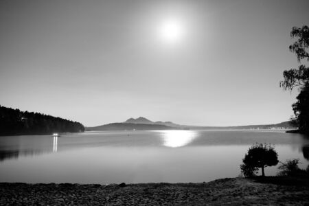 Romantic full moon night at lake, calm water level with moon raysの写真素材