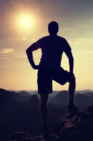 Hiker is standing on the peak of sandstone rock in rock empires park and watching over the misty and foggy morning's Sun Valley Beautiful moment the miracle of natureの写真素材