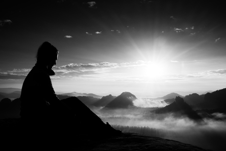 Beautiful  young woman tourist enjoy daybreak on the sharp corner of sandstone rock and watch over valley to Sun.の写真素材