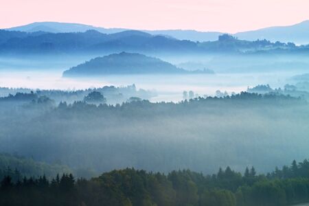 Autumn fog and clouds above freeze  mountain valley, hilly landscapeの写真素材
