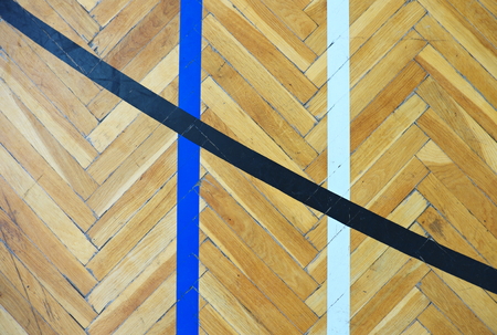 Worn out wooden floor of sports hall with colorful marking lines.の写真素材