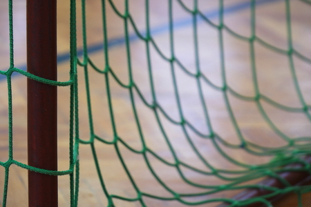 Hang bended soccer nets, soccer net. Handball wooden playground in the background