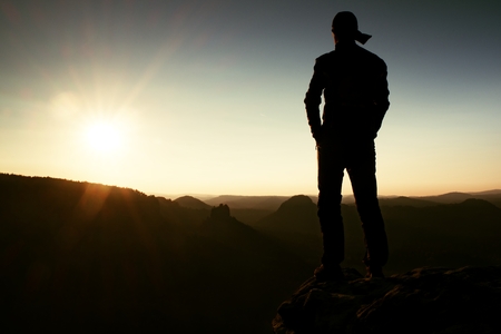 Hiker in long cap on the peak of rock in rock empires park and watching over the misty and foggy morning's Sun Valley Beautiful moment the miracle of natureの写真素材