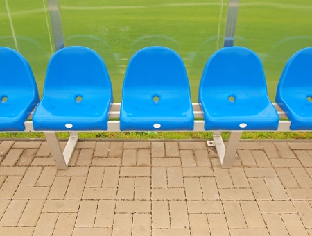 New blue plastic seats. Outdoor stage football players bench, chairs with new paint transparent plastic roof below.の写真素材