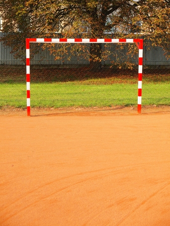 Empty gate. Outdoor football or handball playground, light red crushed bricks surface on groundの写真素材