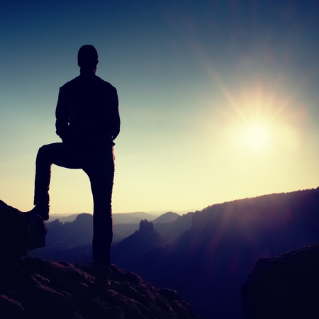 Silhouette of Young Confident and Powerful Man Standing with Hands on Hips, Late Day Sun with Copy Spaceの写真素材