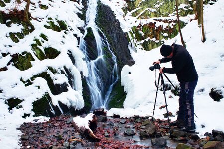 Professional photograph takes with camera on tripod  photo of winter waterfall. Melting of snow.の写真素材