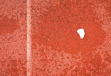 Snow on ground. White lines and texture of running racetrack, red rubber racetracks in outdoor...