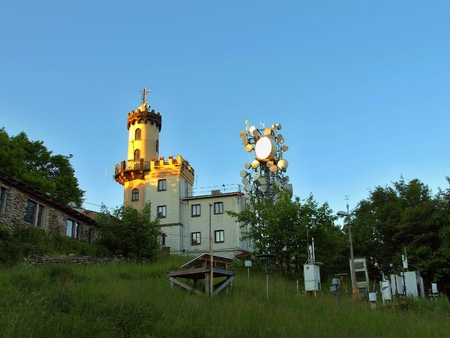 Old building of meteorological observatory. High tower with antennas. Spring morning on the peak of...