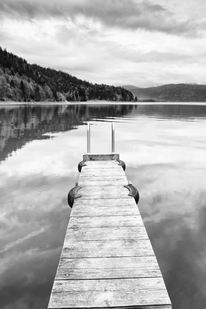 Empty wooden mole on  blue Alps lake, wharf for hired boats in marina. Ready for trip ships.の写真素材