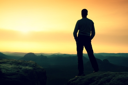 Silhouette of Young Confident and Powerful Man Standing with Hands on Hips, Late Day Sun with Copy Spaceの写真素材