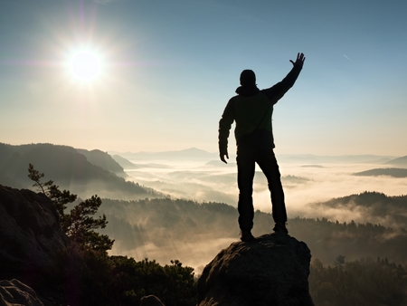 Man silhouette stay on sharp rock peak. Satisfy hiker enjoy view. Tall man on rocky cliff watching...