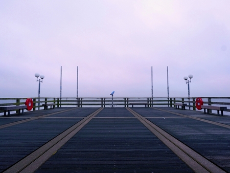 Long touristic mole within The autumn misty morning. Wet and slippery wooden floor, above constrution smooth sea.の写真素材
