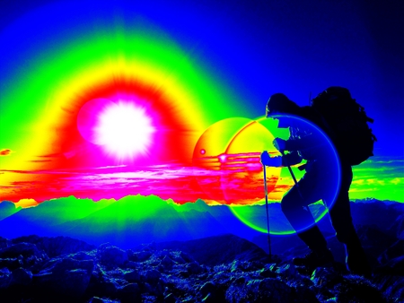 Ultraviolet scan. Infrared photo. Lens flare light, strong defect. Man hiker with rucksack walk on a rocky peak.の写真素材