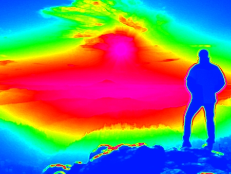 Man on rock. Fantastic infrared scan. Tourist on the rocky peak. Daybreak in mountains, heavy mist in deep valley in colors of ultra violet measurementの写真素材