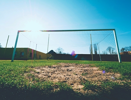 Hang bended blue yellow soccer nets, soccer football net. Grass on football playground in the backgroundの写真素材