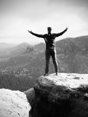 Alone hiker in red cap stand on the peak of sandstone rock in rock empires park and watching over the misty and foggy morning's Sun Valley Beautiful moment the miracle of natureの写真素材