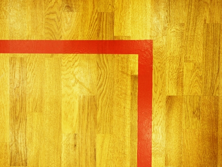 Red corner line. Worn out wooden floor of sports hall with colorful marking linesの写真素材