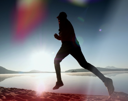Slim young fitness man runner on beach, tropical trail runner.  Cheerful sportsman run on beach...