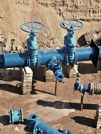 Oil, gas, water industry. Wellhead with valve armature underground. Dug deep trench utilities...
