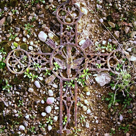 Broken iron rustic   crucifix on old mossy tombstone. Abandoned symbol of religion.の写真素材