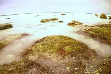 The misty seascape within ebb. Cold spring weatherの写真素材