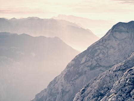 View over high sharp mountain peaks from plane, beautiful view. Fantastic dreamy sunrise, sharp contour of mountain above mist. Dreamy unlear view.の写真素材