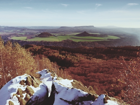 Cold spring golden daybreak. Snow on ground. Peaks of forests Increased from the yellow and orange fog with sun rays.の写真素材