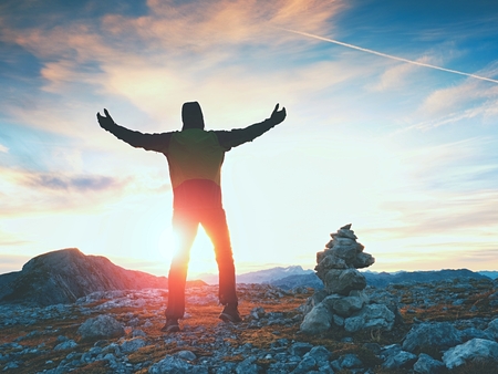 Stones pyramid on Alpine gravel mountain summit. Daybreak horizon above blue mist in valley. Mountains increased from horizoonの写真素材