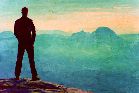 Film grain effect. Hiker is standing on the peak of sandstone rock in rock empires park and watching over the misty and foggy morningHiker is standing on the peak of sandstone rock in rock empires park and watching over the misty and foggy morningの写真素材