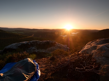 Beautiful awakening in  rocks.  Sleeping in nature in sleeping bag. View from rocky peak over forest valley.の写真素材