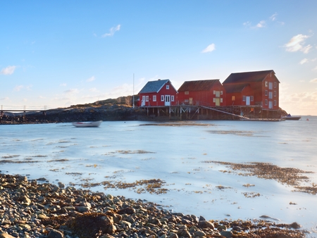 Red houses of the fishing village. Traditional red white building in small port, coastline of cold...