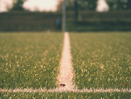 Raw rubber of Winter Soccer Turf. Close-up of artificial grass field on football playground. Plastic pieces, leaves, grass and finely ground black rubber.の写真素材