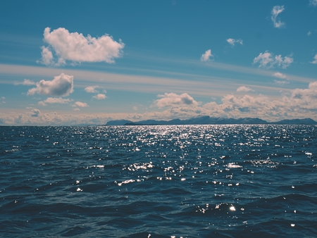 Small water waves passing, water level in colorful shadows moving with sparkles and light reflectionsの写真素材