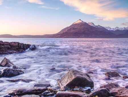 Evening rocky shore with sea water and large cracked rocks with erosion marks.  Rocky coastline with sea water.

の写真素材