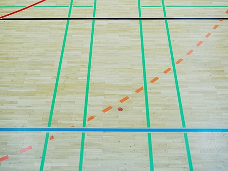 School gym floor. Wooden floor of sports hall with colorful marking lines
