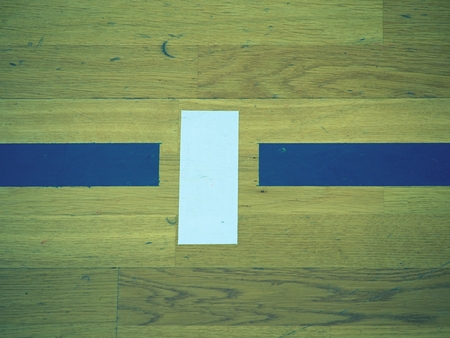 Close Up view of wooden floor Basketball Court.  Sporting hall with strong lightning, sratches in the transparent paintの写真素材