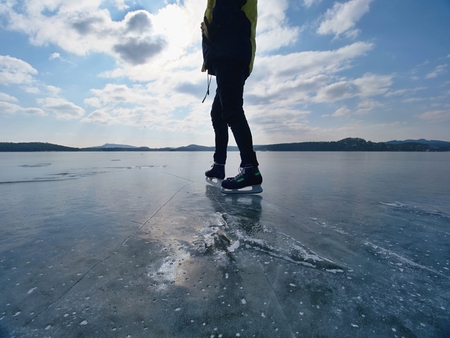 Silhouette of a boy skating on ice on  lake against to winter sun.の写真素材