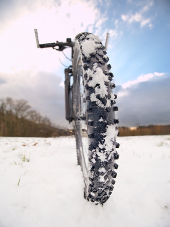 Front bike detail on a winter trail, path covered by snow. Sportive backgrounds and still-life. Biking in the countryside.の写真素材