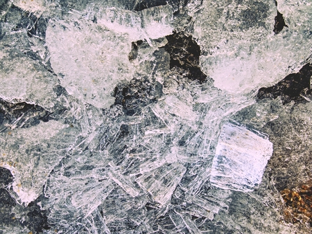 Pieces of clear natural ice on frozen lake,  very close up view. Early mealting of ice, ecology problem.の写真素材