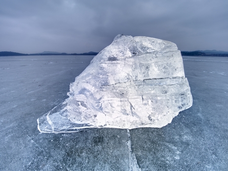 Ice floe and crushed ice on dark frozen and flat  ground. Shining crushed ice in strong colorful backlight.の写真素材