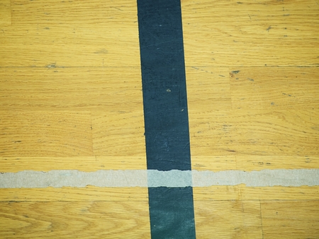 Play field markings on the floor in the gym. Worn out wooden floor in school sporting hall.の写真素材