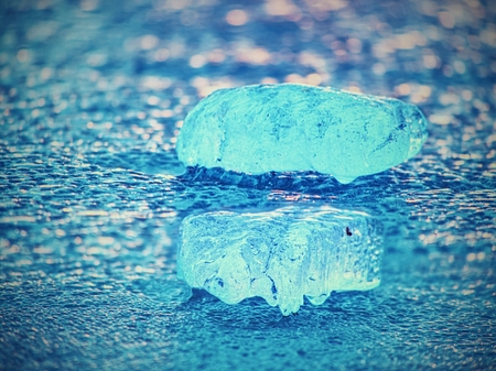 Shining icebergs and ice floes, ice clefts reflected rays in the smooth water surface. Drift ice in lagoon.の写真素材