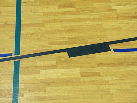 Play field markings on the floor in the gym. Worn out wooden floor in school sporting hall.の写真素材