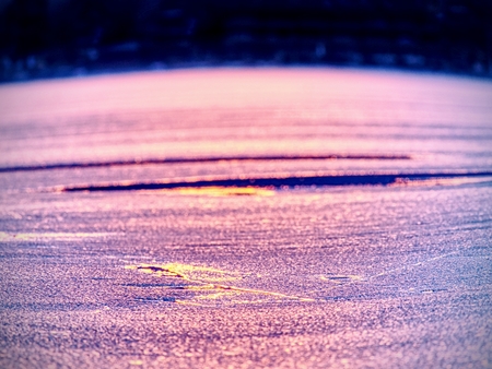 Selective focus to ice floes reflected sunset colors. Ice on the smooth water surface. Unique nature colors.の写真素材